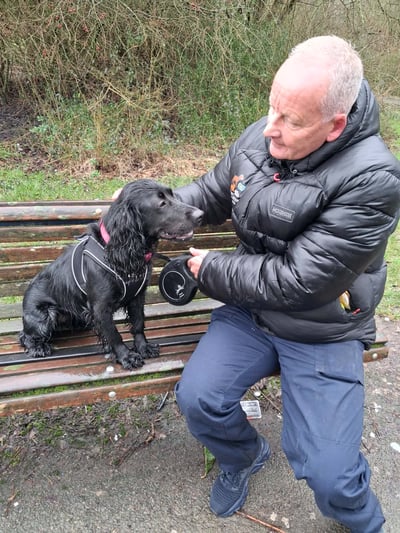 Pete from Trusted Steps Pet Service with a Cocker Spaniel on a park bench in Corby